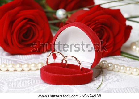 stock photo Wedding rings in red box against beautiful red roses on lace 