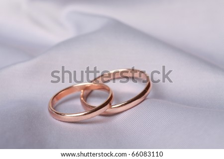 stock photo Two wedding rings on light blue silk background