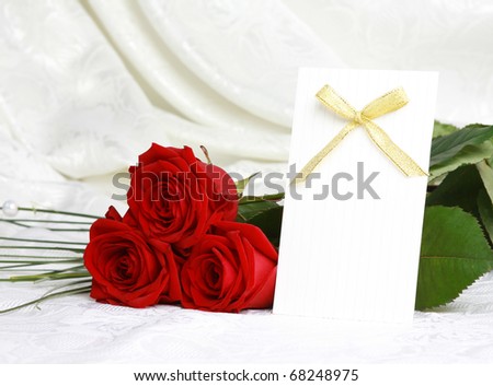Beautiful red roses and invitation card on lace background