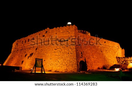 Tower of St. Nicholas in Rhodes (Greece) by night - Bluelight. Motion blur on greek flag and sail masts. Original colors.