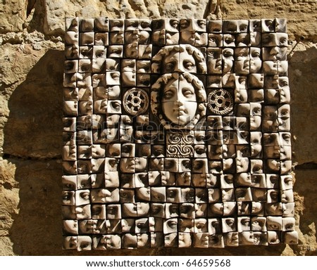 Ceramic panels depicting people\'s heads, side light