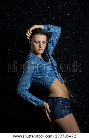 Beautiful wet girl in water on a black background