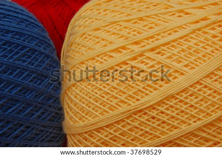 Yellow crochet thread with blue and red in the background