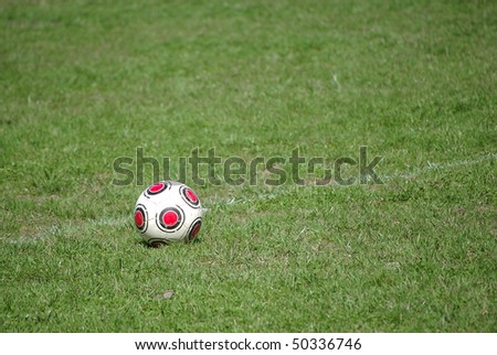 An old, worn soccer ball on a chalk line on a soccer field