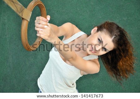 Young woman playing sport rings on the sports ground