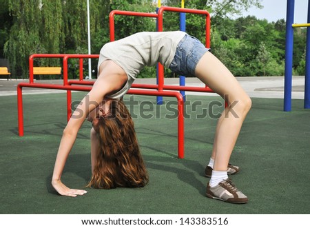Young woman doing gymnastics at sports ground in the park