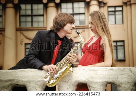 Couple. Man with sax and woman in the park