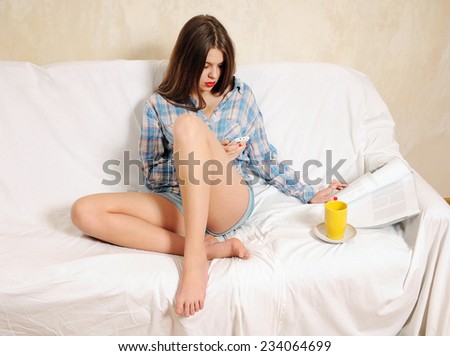 Girl in chair with phone, magazine and cup