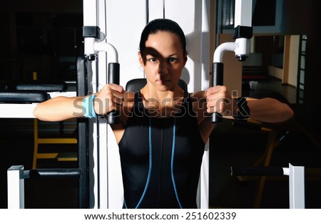 Woman in gym. Beautiful muscular fit woman exercising building muscles