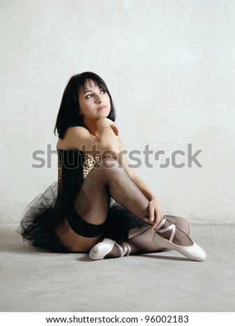 Ballerina. Young woman in ballet outfit sitting on the floor