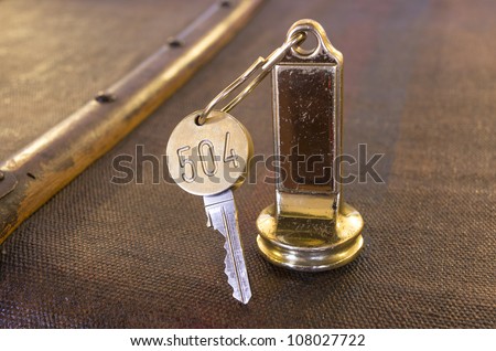 brass keys in an old key-chain on a worn-out large suitcase.