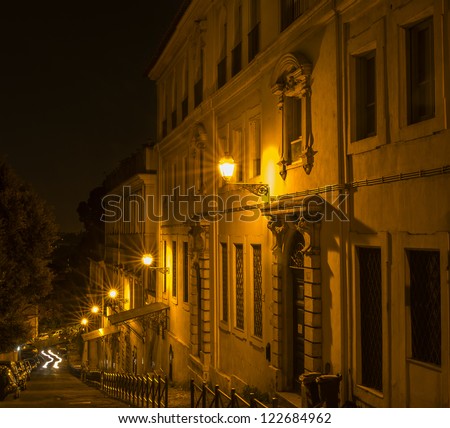 Multiple neon lights with starbursts lighting a street and office buildings, Rome, Italy.