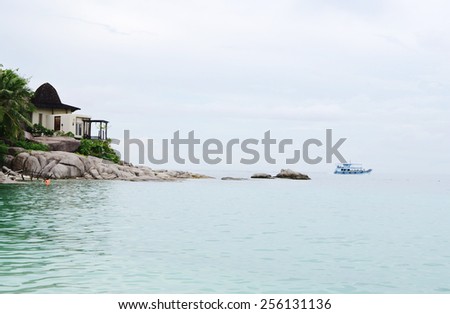 Marine landscape with house on hill and ship on the horizon. Koh Nanguan, Thailand.