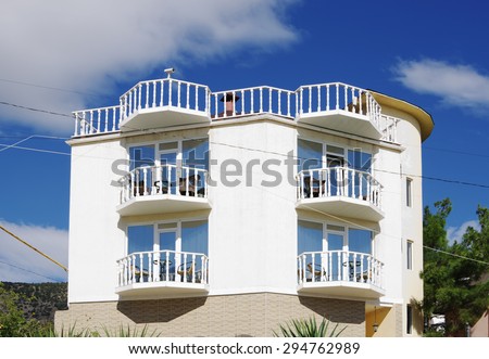 NOVYY SVET, RUSSIA - SEPTEMBER 25, 2014: Private two-story white hotel with balconies closeup  against blue  cloudy sky in resort township.