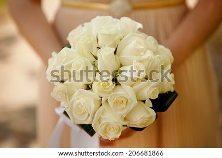 Bride holding wedding flower bouquet of yellow roses
