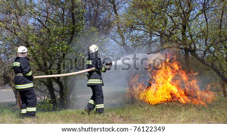 Firefighters extinguish a fire in a forest fire by water flooding