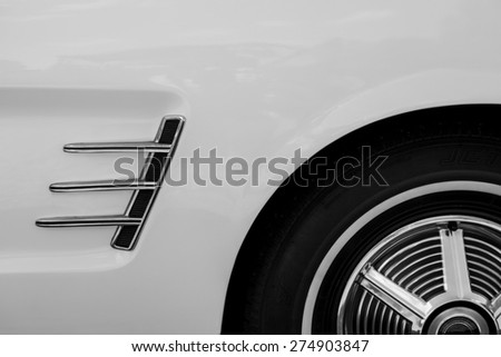 Detail of a vintage classic car consisting of wheel and air flow vent
