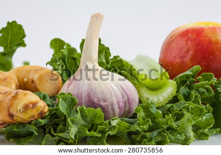 Ingredients for kale shake on white background extreme closeup - ginger, garlic, kale, pink lady apple, celery