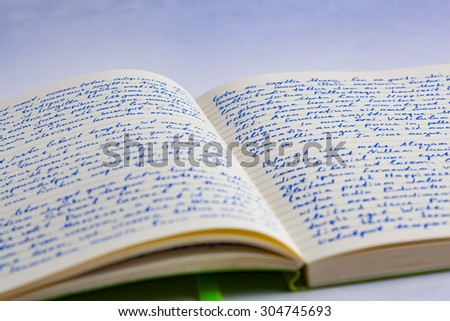 Extreme closeup of open notebook with handwritten  lorem ipsum text with shallow focus on a ruled background
