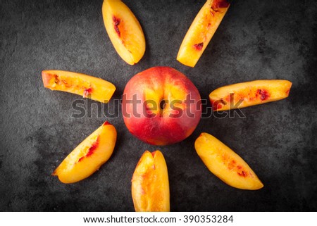 Yellow nectarine peach - whole and sliced on dark grunge background. Top view