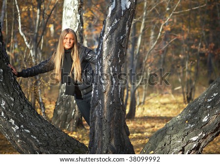 Girl with long hear near autumn trees