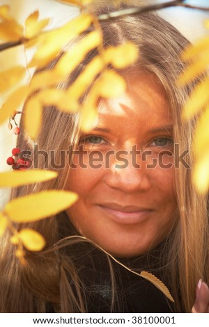 Girl with long hear near mountain ash smiling