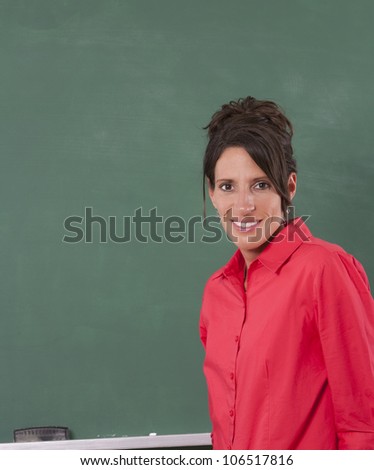 Teacher standing in front of chalkboard of classroom