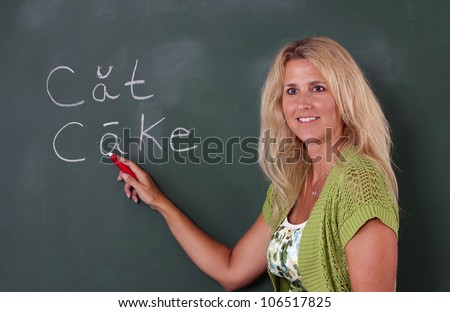 Elementary teacher at chalkboard teaching class.