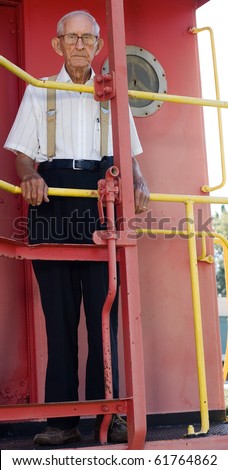 Old man standing on back of abandoned train.