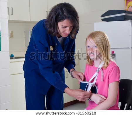 School nurse checking a sling for broken arm on student patient