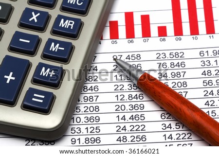Close up of a calculator, financial figures and pen.