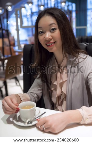 Affable beautiful Korean woman with a cup of coffee