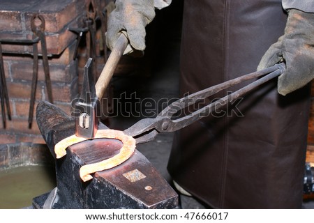 The smith in a smithy forges a horseshoe