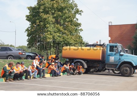 MOSCOW - AUGUST 30: workers sitting on a border and cargo tank on \