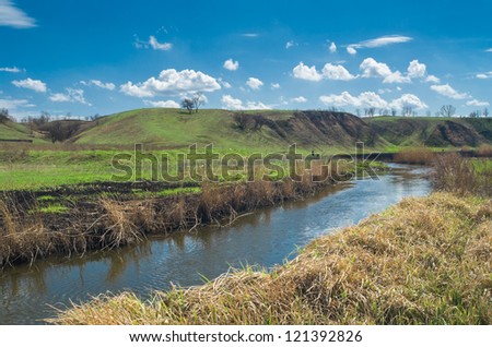 Ukrainian rural landscape with small river Sura at early spring season.