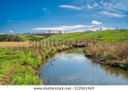 Rural landscape with small river at early spring season.