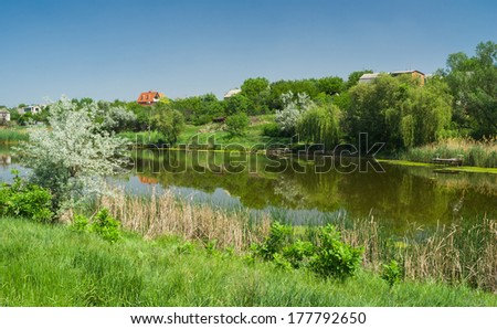 Ukrainian rural summer landscape with small river Sura in spring season.