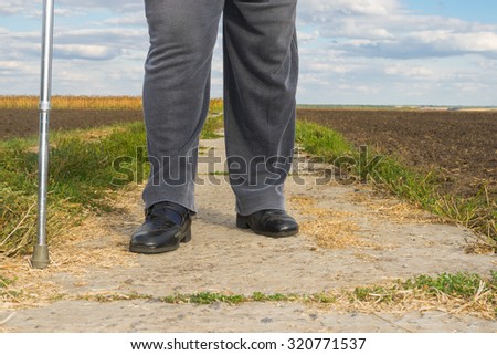 Chubby man with walking stick doing hard step outdoor