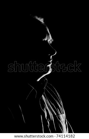 Portrait (low key, face outline) of a Caucasian man  - black and white.