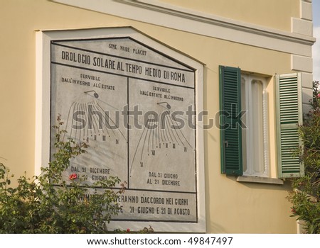 Double  sundial (summer and winter time) on a yellow house. The sundial shows Rome\'s time.