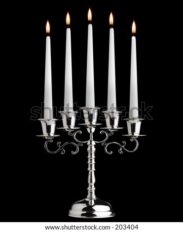 five white candles standing on an elegant silver candle stand