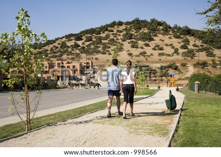 Couple walking in a suburban development on a summer day