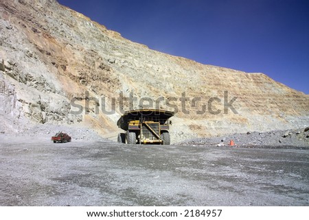 A picture of a big mining truck taken at a copper mine contrasts with a normal pick-up