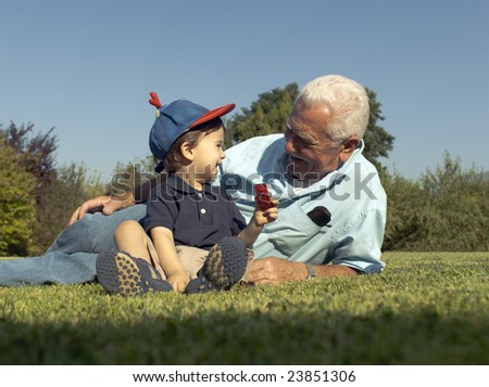 Grandfather and grandson smiling over the grass