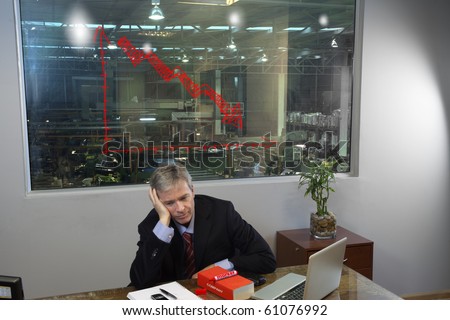 Sad depressed manager in his office with a chart showing loss
