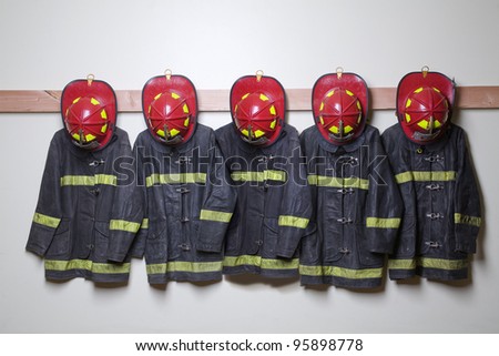 Firemen suits and helmets hanging inside a room