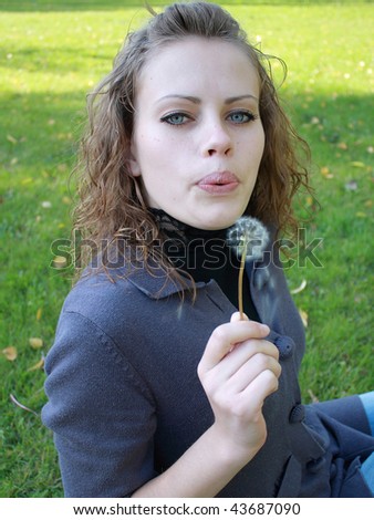 young  girl holds a dandelion in a hand