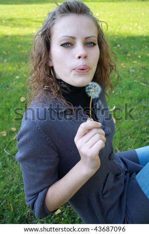 young girl holds a dandelion in the hand
