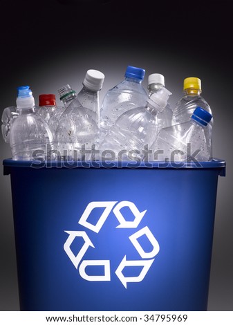 Plastic bottles in trash bin with recycle sign