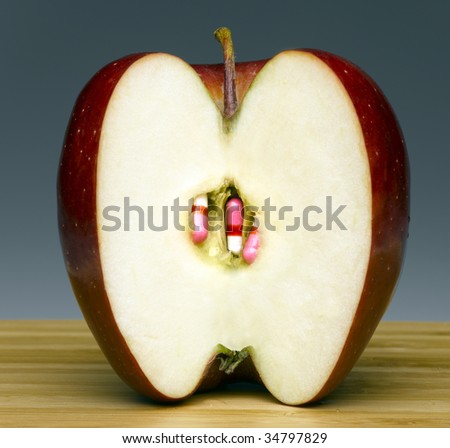 Cross section of apple with pills in place of seeds
